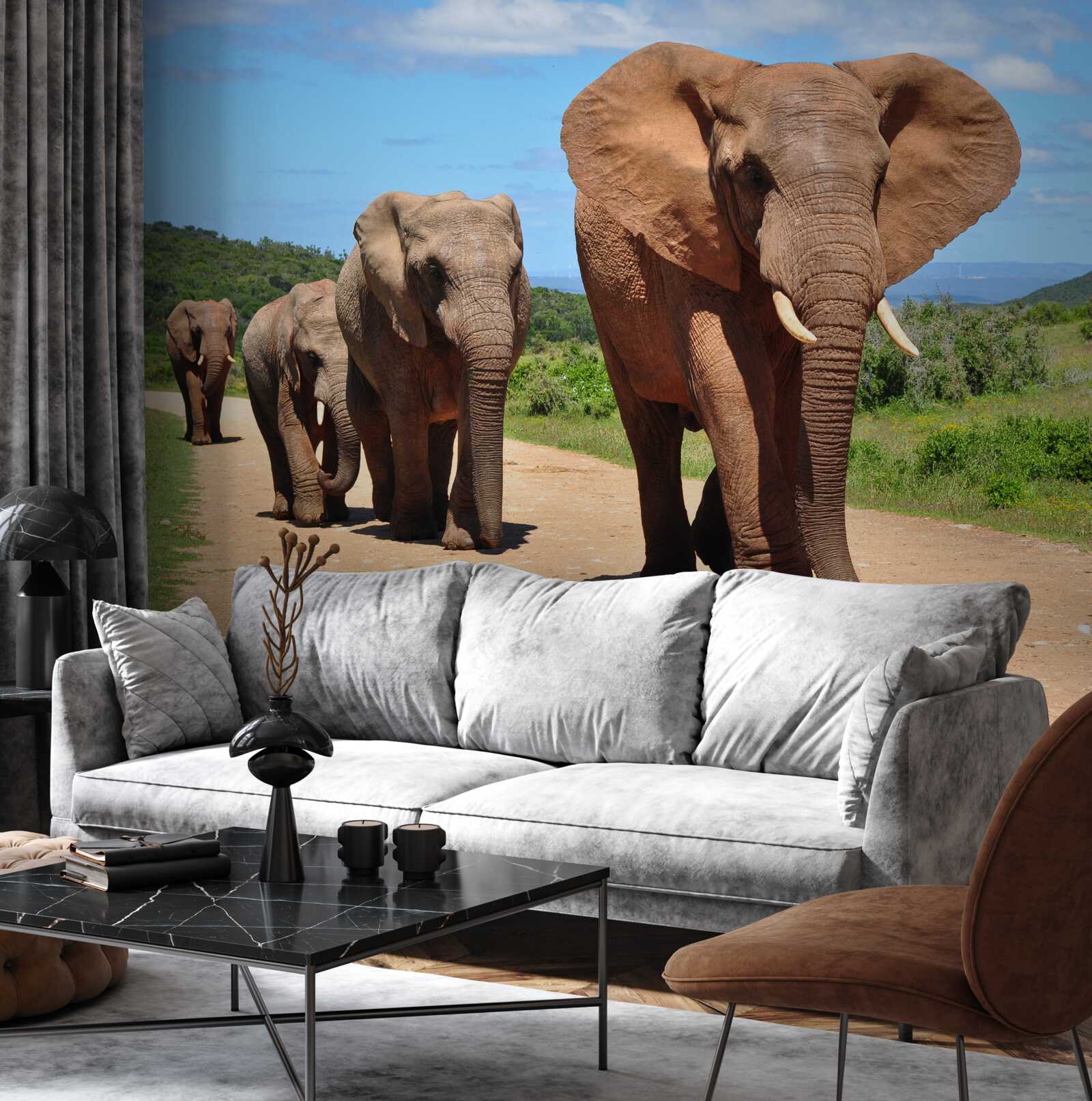 Papier peint Un groupe d'éléphants rentre chez lui en traversant un terrain sablonneux.