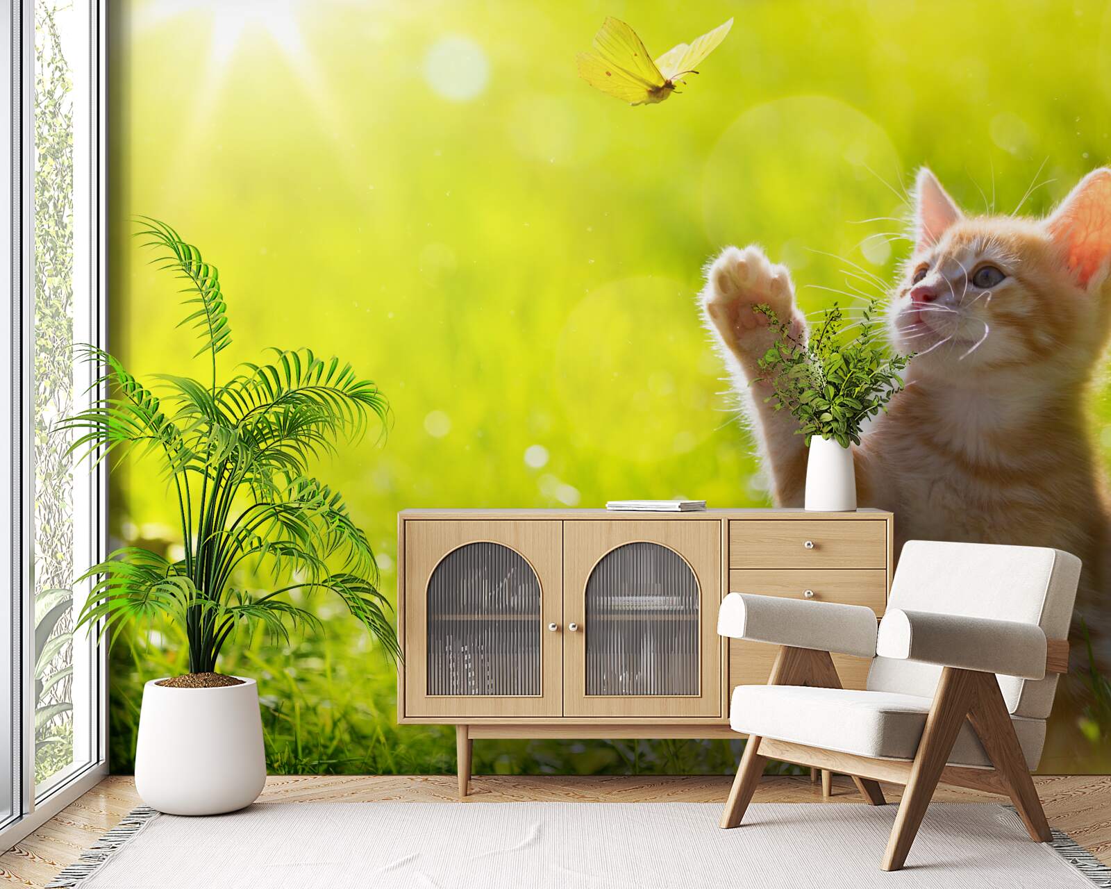Papier peint un petit chat joue avec un papillon dans un champ vert