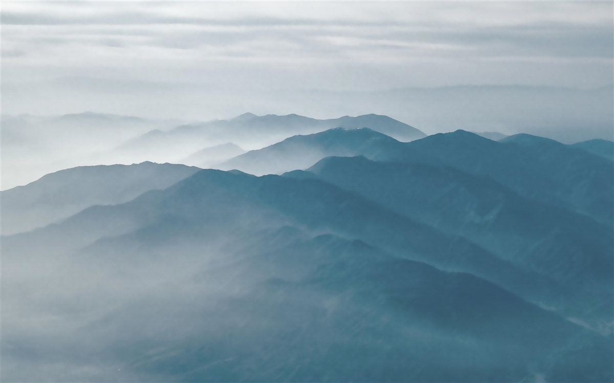Papier peint la brume matinale recouvre les sommets des montagnes