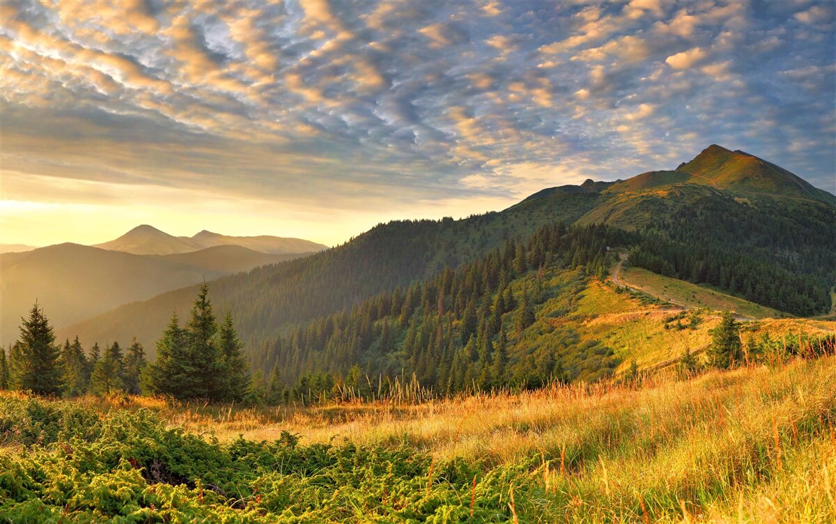 Papier peint les nuages au-dessus des montagnes sont peints dans les couleurs chaudes du coucher de soleil