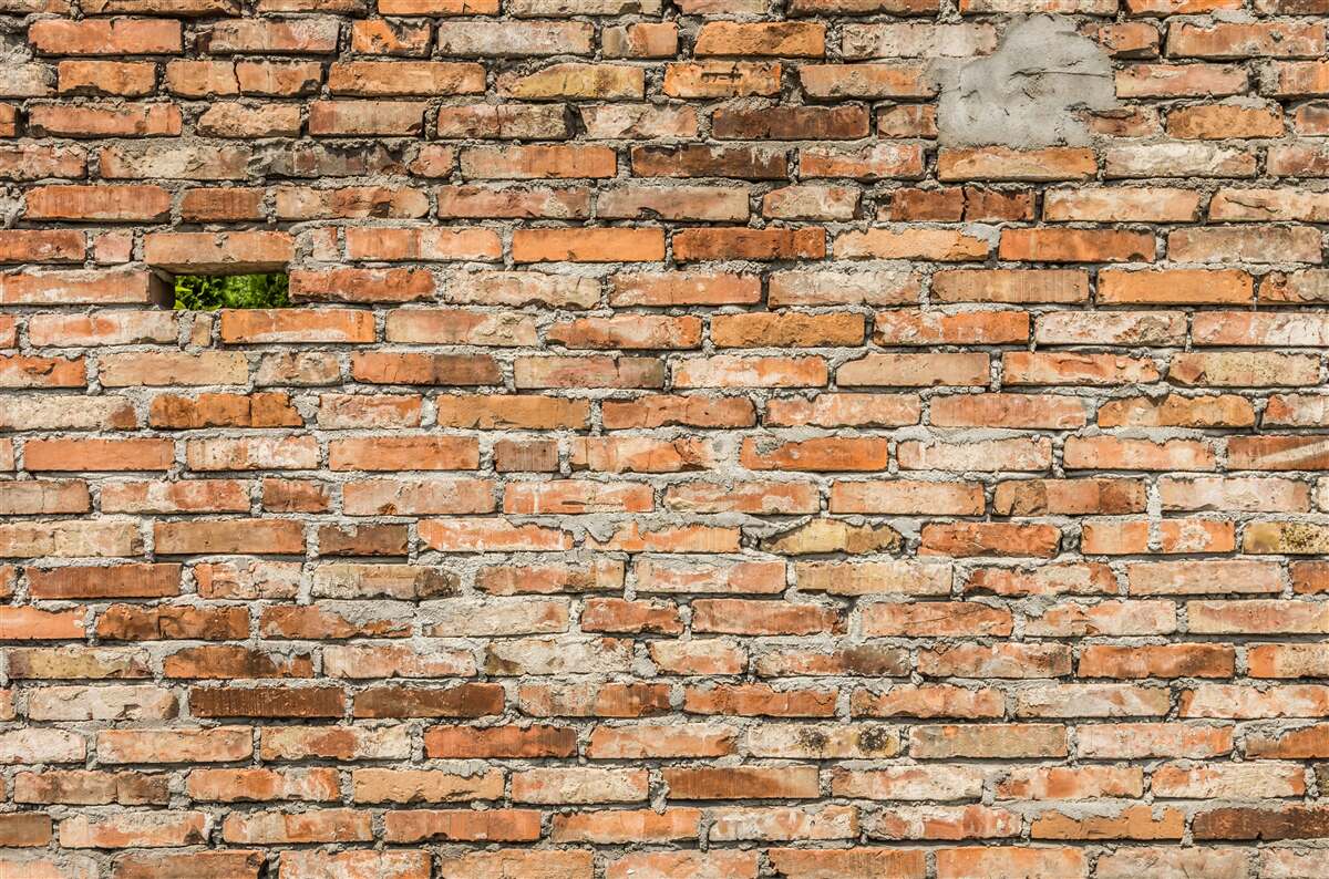 Papier peint Un mur dont les briques tombent et ont perdu leur fraîcheur