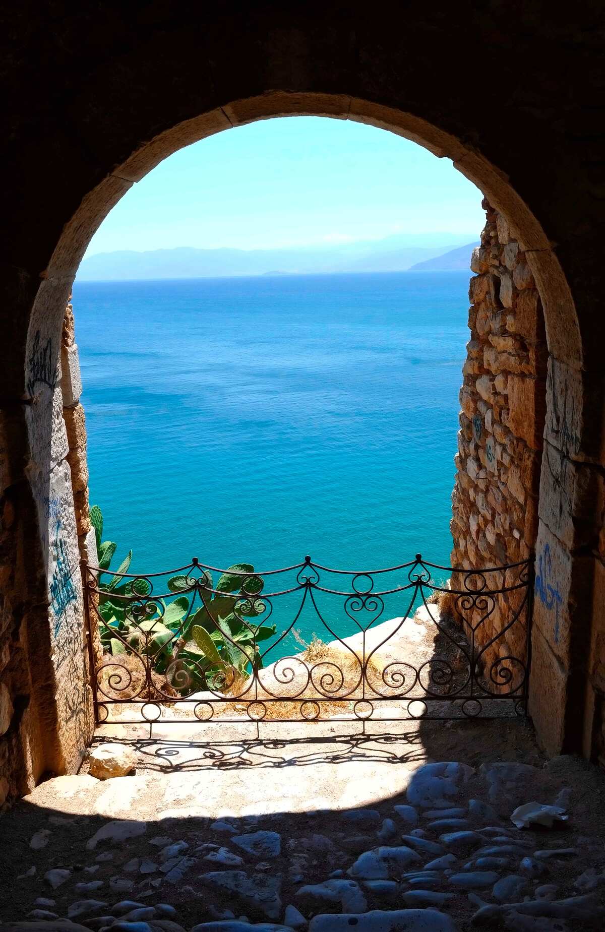 Papier peint arche de pierre menant à la mer