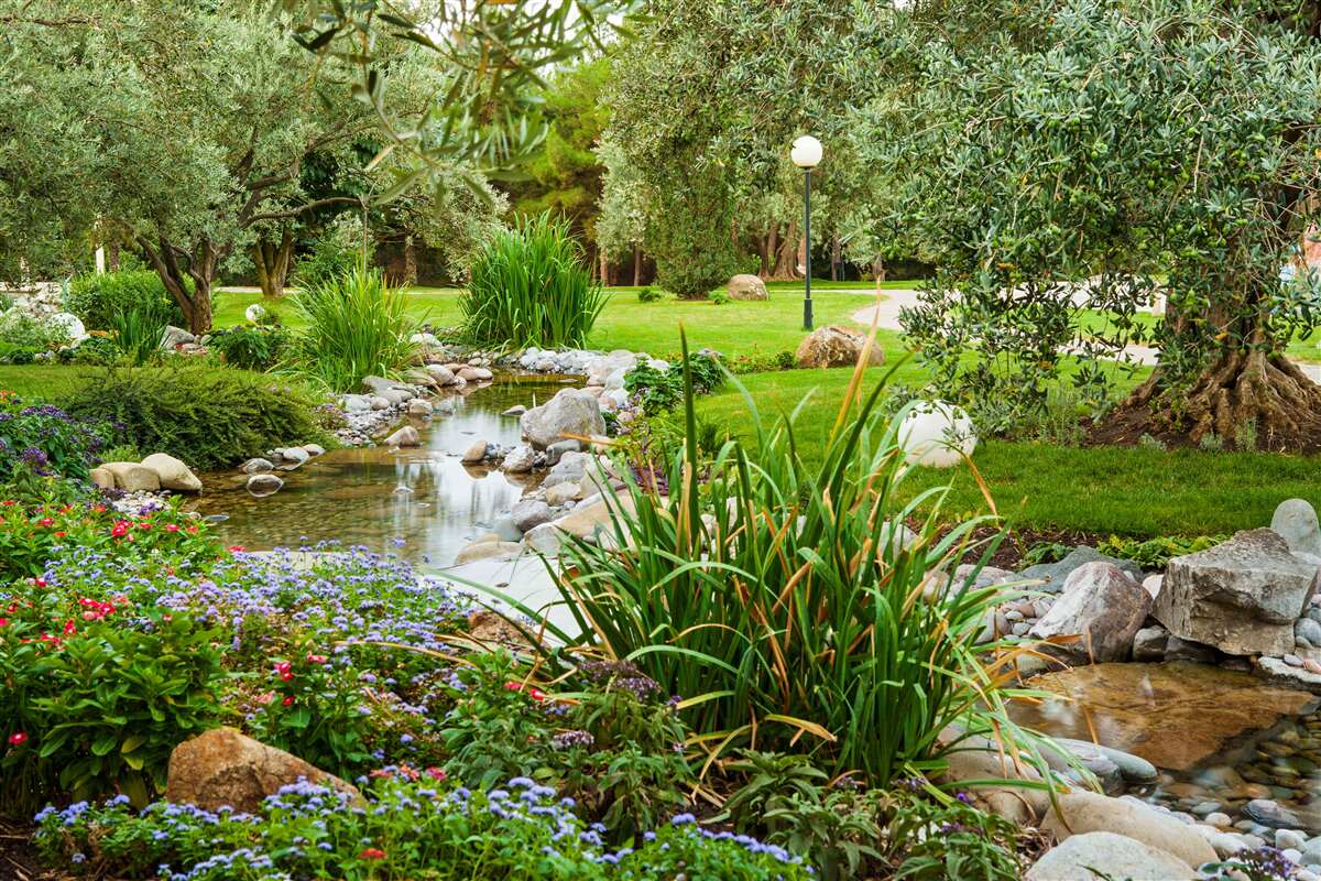 Papier peint un ruisseau qui coule dans une prairie verdoyante