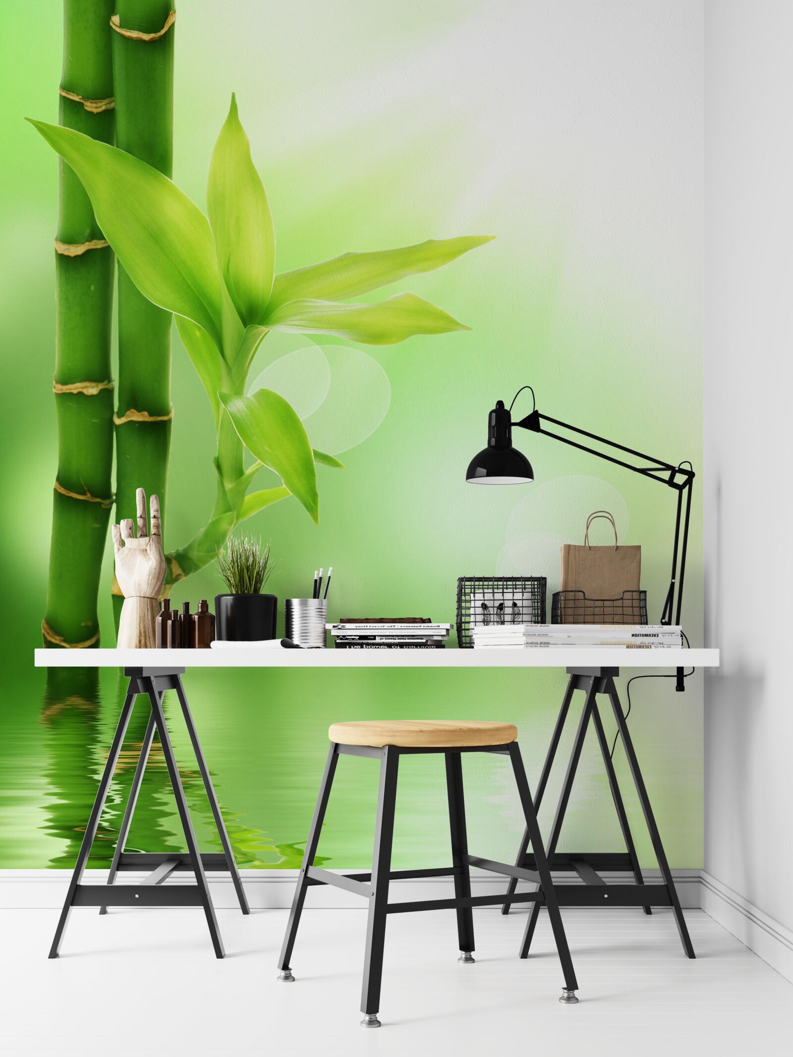 Papier peint une branche de bambou avec des fleurs à la surface de l'eau